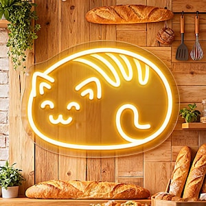 May include: A glowing neon cat sign in a warm yellow hue, mounted on a wooden wall. The sign is shaped like a sleeping cat. Breads and kitchen utensils are also visible.