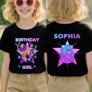 May include: Black t-shirt with a colorful graphic featuring the text "BIRTHDAY GIRL" and a group of animated characters. The back of the shirt displays the name "SOPHIA" and the number "5" in a star design.