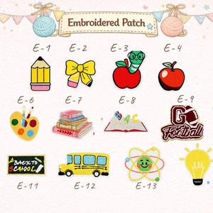 May include: A collection of fourteen embroidered patches labelled E-1 through E-14, featuring school-themed designs including a pencil, bow, apple with worm, apple, crayons, paint palette, books, open book, football, trophy, chalkboard, bus, atom, and lightbulb.