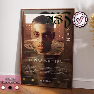 Może przedstawiać: Plakat albumu "It Was Written" rapera Nasa. Plakat przedstawia zbliżenie twarzy Nasa, z tytułem albumu i listą utworów wydrukowanych poniżej. Plakat jest oprawiony w brązową drewnianą ramę.