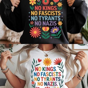 Peut inclure: Sweat-shirt noir et t-shirt blanc avec l'inscription "NO KINGS, NO FASCISTS, NO TYRANTS, NO NAZIS" en couleurs vives. Le design comprend des motifs floraux et en forme de cœur.