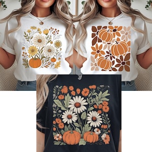 Peut inclure: T-shirts blancs et marine avec des motifs sur le thème de l'automne. L'un présente un arrangement floral avec des citrouilles, un autre un motif de citrouille et de fleurs, et le troisième un motif floral et de citrouille.
