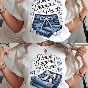May include: White t-shirt featuring a graphic design with the text "Denim Diamond and Pearls". The design includes a pair of denim shorts, pearls, and diamond accents. The shirt has rolled-up sleeves.