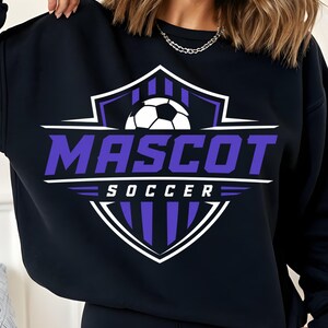 Peut inclure: Un sweat-shirt noir à manches longues avec un motif graphique représentant un ballon de football blanc au-dessus du mot MASCOT en grandes lettres violettes, avec le mot SOCCER en petites lettres blanches, le tout sur un écusson violet et blanc.