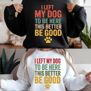 May include: Black and white sweatshirts with the text "I LEFT MY DOG TO BE HERE THIS BETTER BE GOOD" in red, green, and yellow. A paw print graphic is below the text. The sweatshirts are long-sleeved.