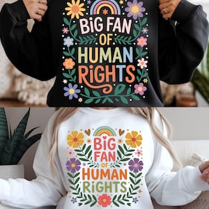 以下が含まれることがあります： 「BIG FAN OF HUMAN RIGHTS」の文字がカラフルな黒と白のスウェットシャツ。デザインには虹、花、葉が含まれています。スウェットシャツは快適でカジュアルなスタイルです。