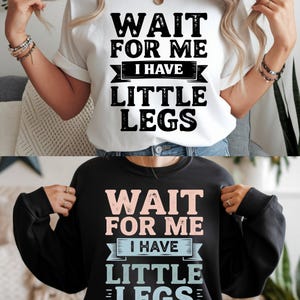 Peut inclure: Un t-shirt blanc et un sweat-shirt noir, tous deux avec l'inscription "WAIT FOR ME I HAVE LITTLE LEGS" dans une police audacieuse et amusante. Le texte est en noir sur le t-shirt blanc et en couleurs pastel sur le sweat-shirt noir.