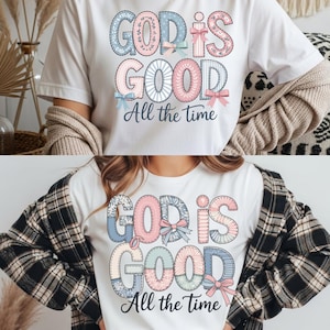 May include: White t-shirts with the text "GOD IS GOOD All the time" in a patchwork design. The text is in pastel colors with bow accents. The shirts are short-sleeved and suitable for casual wear.