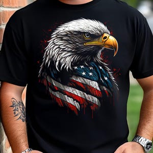 Peut inclure: T-shirt noir avec un aigle américain stylisé, intégrant le drapeau américain. La tête de l'aigle est blanche, avec un bec jaune et des yeux perçants. Le design comprend des accents rouges et bleus. Col rond et manches courtes.