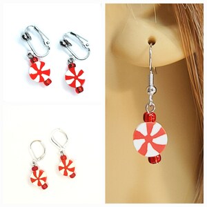 May include: Three pairs of candy cane earrings. One pair has clip-on backs, another has lever-back closures, and the third has fish hook style ear wires. Each earring features a red and white candy cane design with red beads.