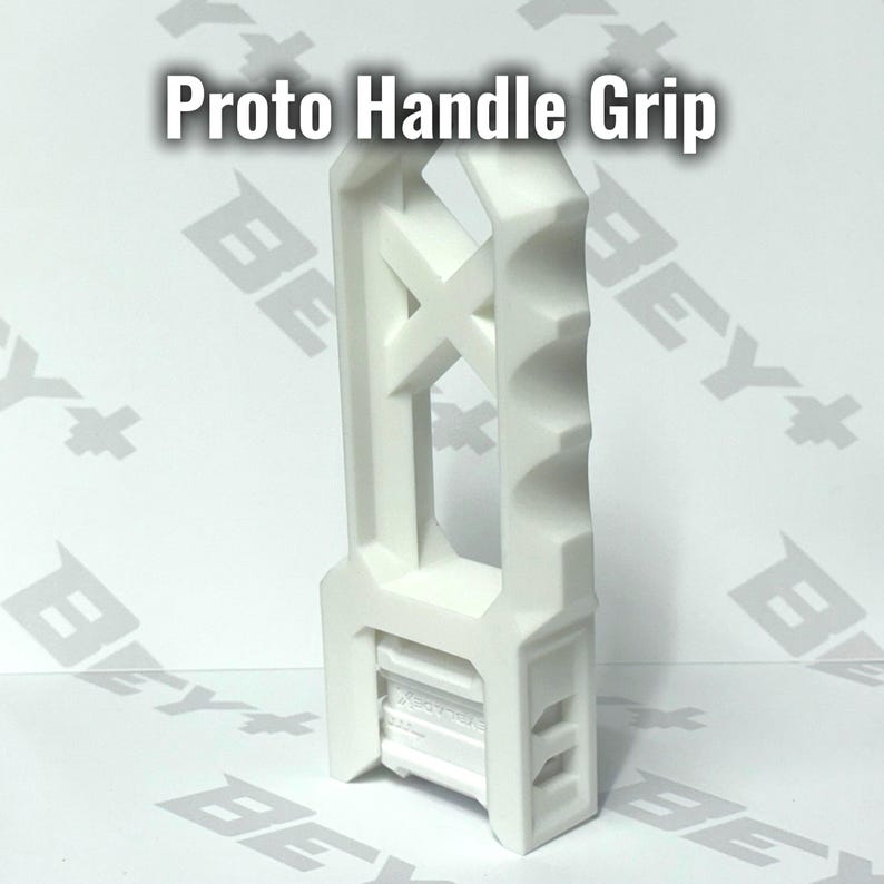 May include: A white Proto Handle Grip featuring a vertical, elongated structure with a scalloped edge for finger placement and a central X-shaped support. The base includes a rectangular attachment point with visible mechanical details.