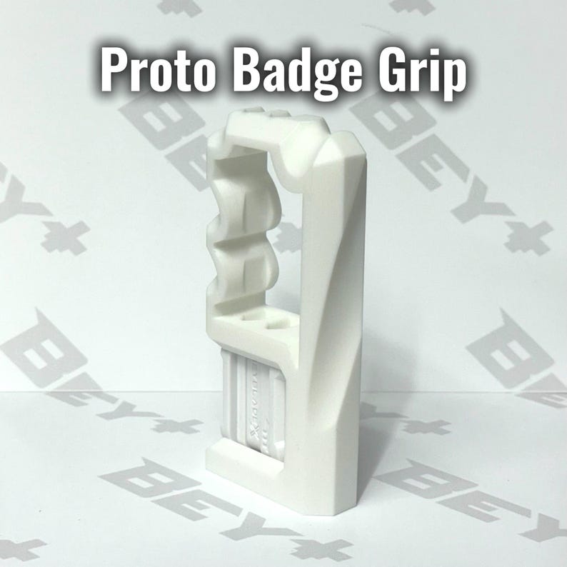 May include: A white Proto Badge Grip accessory featuring a vertical, angular frame with a textured, wavy side profile and a rectangular base section. The object is displayed against a white background with the text Proto Badge Grip visible.