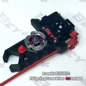 May include: A black and red plastic Beyblade launcher with a silver and red spinning top attached. The device features the text BEY and includes a red ripcord. Text on the image reads: Assembly REQUIRED: Philips Head Screw Driver- Not Included.