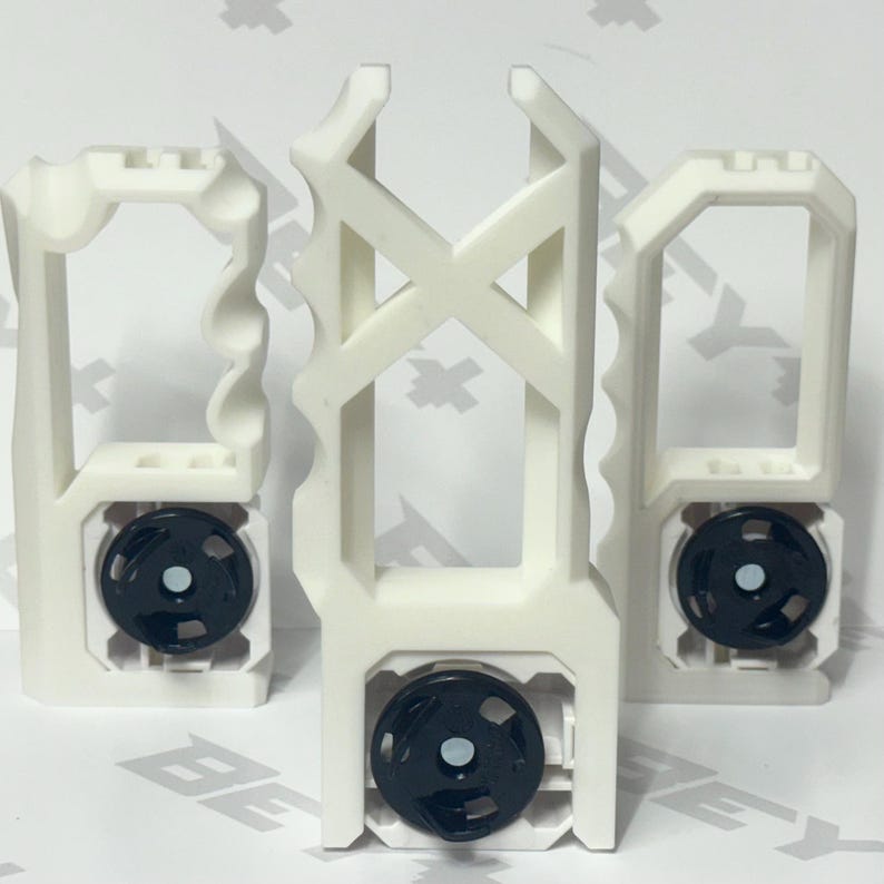 May include: Three white 3D-printed plastic handles with distinct geometric shapes and ergonomic finger grips. Each handle features a circular black mechanical component at the base with a central silver-colored metal fastener or magnetic insert.
