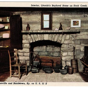 May include: An interior view of Lincoln's Boyhood Home on Knob Creek, 1811-1816. The image shows a stone fireplace, a wooden cabinet with shelves, and various antique kitchen items. The text "Between Hodgenville and Bardstown, Ky. on U. S. 31 E" is visible.