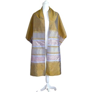 May include: A gold-colored silk shawl with a striped design in light blue, gold, and lavender. The shawl is displayed on a white mannequin. The sleeves are short and the shawl is open in the front.