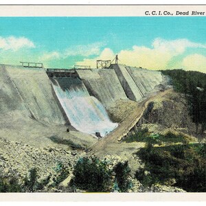 May include: Vintage postcard featuring the Dead River Storage Dam. The image shows a large concrete dam with water cascading down. The sky is blue with white clouds, and the surrounding landscape includes trees and rocks. Text at the top reads "C. C. I. Co., Dead River Storage Dam."