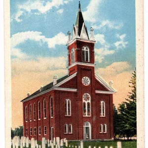 May include: Vintage postcard featuring the Oley Reformed Church, erected in 1822. The red brick church has a tall steeple and multiple arched windows. The sky is blue with scattered clouds. The church is surrounded by a green lawn and white tombstones.