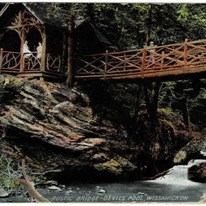 May include: A rustic wooden bridge over a stream in a wooded area. The bridge is made of rough-hewn logs and has a wooden railing. The stream is flowing over rocks and there are trees on both sides of the bridge. The text "RUSTIC BRIDGE - DEVILS POOL WISSAHICKON" is printed at the bottom of the image.