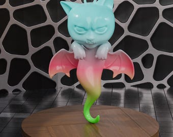 May include: A whimsical figurine of a cat-like creature with a grumpy expression. The figure has a light blue head, white paws, and a body that fades from pink to yellow-green. It has pink wings and is displayed on a wooden table.