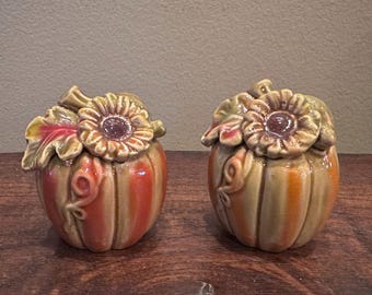 Saleros y pimenteros vintage con forma de calabaza, decorados con girasoles y hojas de otoño.