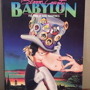 Könnte beinhalten: Ein Taschenbuch mit dem Titel Bloom County Babylon: Five Years of Basic Naughtiness von Berke Breathed. Das Cover zeigt einen Cartoon-Pinguin mit einem grauen Zylinder, der mit zahlreichen bunten runden Anstecknadeln verziert ist.