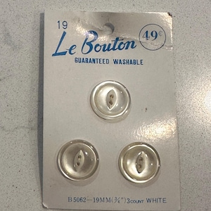 May include: A card of three clear, white buttons. The card reads "Le Bouton" and "Guaranteed Washable." The buttons are 19mm (¾") in diameter. The card also states "3 count white."