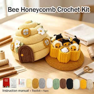 Op de afbeelding: Een Bee Honeycomb haakpakket met een grote gele gehaakte bijenkorf met een bruine deur en witte bloemen, een gele honingraatstructuur met kleine gehaakte bijtjes, plus garenbollen, gereedschap en een instructiehandleiding.