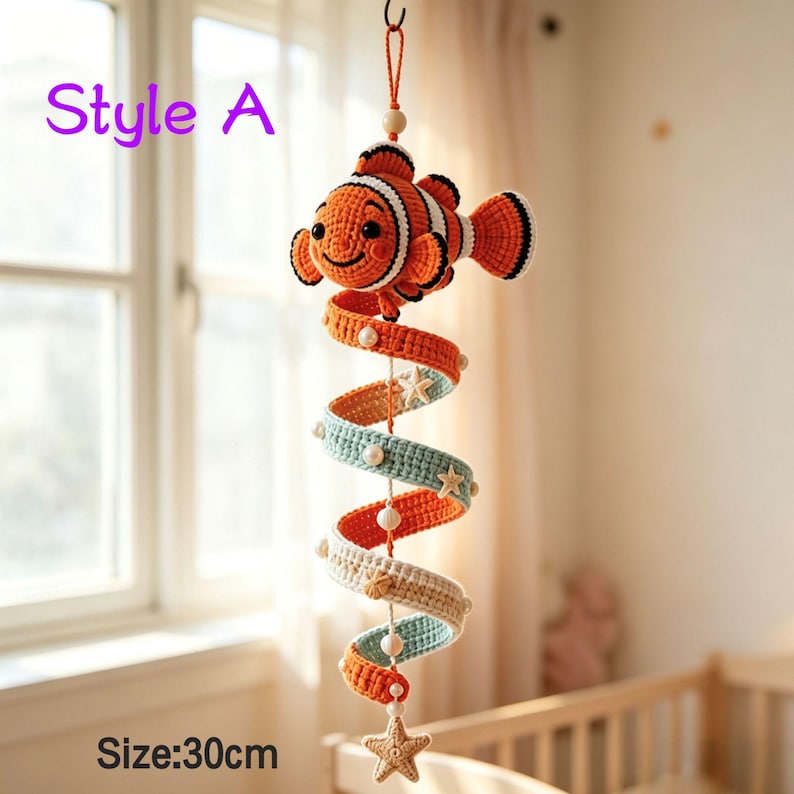 May include: A hanging crochet mobile featuring a clownfish at the top, followed by a spiral structure in orange, light blue, and cream colors. The spiral is decorated with small white beads and crochet starfish. The text Style A and Size:30cm are visible.