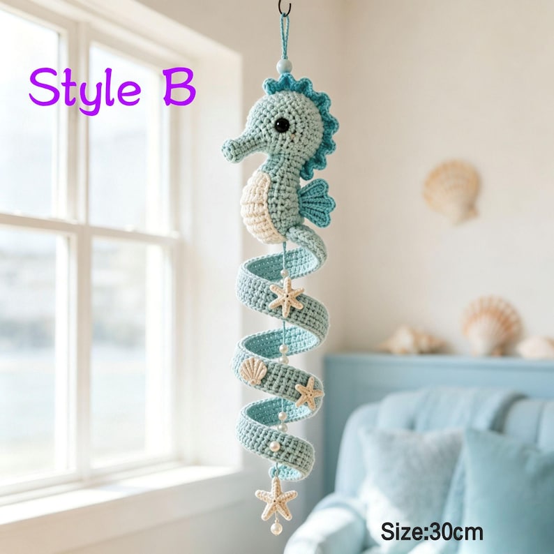 May include: A hanging crochet seahorse mobile in light blue and cream, featuring a spiral tail adorned with small white beads and cream-colored starfish accents. The text Style B and Size: 30cm are visible on the image, indicating the product length.