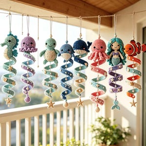 May include: A collection of eight hanging crochet ornaments featuring various sea creatures including a seahorse, jellyfish, turtle, whale, octopus, mermaid, and clownfish, each attached to a spiraling tail decorated with small starfish and shells.