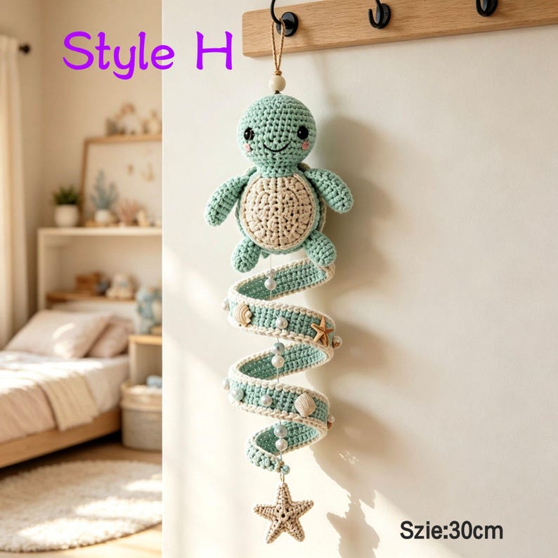 May include: A hanging crochet turtle mobile featuring a light green turtle with a cream-colored shell, attached to a spiraling green crochet ribbon adorned with small white beads, seashells, and a starfish, measuring 30 cm in total length.