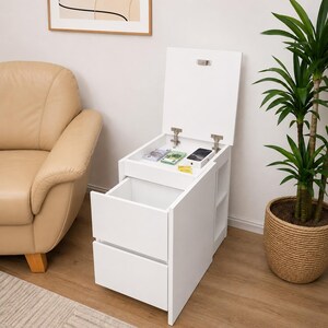 May include: A white bedside table with two drawers and a top compartment that opens with a hinged lid. The open top section reveals a flat storage area, while the side of the unit features open shelving. The piece is finished in a smooth white.
