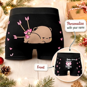 May include: Black boxer briefs featuring a cartoon bear with three arrows in its rear, surrounded by pink hearts. An inset shows the front view with the text Bubu will get me on the naughty list and a small bear graphic inside a pink heart.