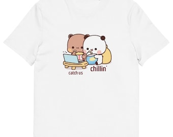 May include: White t-shirt featuring a cartoon illustration of a brown bear and a panda bear. The bears are sitting together, eating snacks, and watching a laptop. The text "catch us chillin'" is printed below the bears.