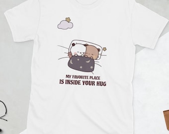 May include: White t-shirt featuring a cartoon illustration of two bears cuddling under a blanket. The text "MY FAVORITE PLACE IS INSIDE YOUR HUG" is printed below the graphic. A cloud and star are also included in the design.