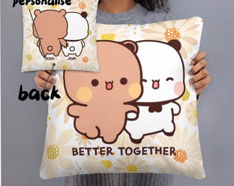 May include: A decorative pillow with a cartoon bear couple design. The pillow features a light brown bear and a white bear hugging, with the words "BETTER TOGETHER" below. The background is a white floral pattern. A smaller pillow shows the back of the bears with the names "JOSH" and "JENN".