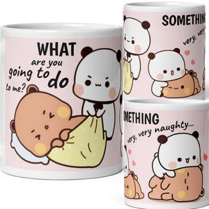 Könnte beinhalten: Weiße Keramik-Tasse mit Cartoon-Panda- und Bärenfiguren auf rosa Hintergrund. Die Tasse zeigt die Sätze "WHAT are you going to do to me?" und "SOMETHING very, very naughty..."