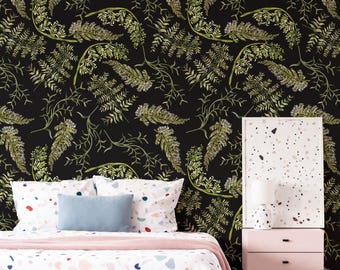 Puede incluir: Una habitación con una cama con una funda nórdica blanca con estampado de terrazo y almohadas. Una almohada azul claro encima. El fondo es una pared negra con un estampado de helechos verdes. Una mesita de noche rosa con una lámpara está a la derecha.