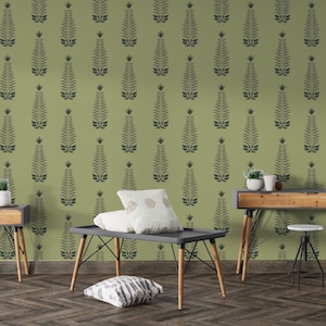 Puede incluir: Una habitación con papel pintado verde con un patrón floral gris oscuro repetido. La habitación incluye un escritorio de madera, una mesa pequeña y una mesa de centro con almohadas. Los muebles tienen patas de madera y un diseño moderno.