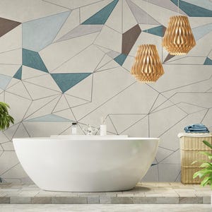 Puede incluir: Un baño moderno con una bañera blanca de forma ovalada. El fondo es un papel pintado geométrico en tonos grises, turquesa y marrón. Dos lámparas colgantes de madera cuelgan. Plantas y una cesta de mimbre añaden elementos naturales.