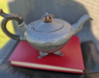 Antique pewter teapot with turned wooden feet and handle