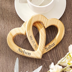 May include: A white ceramic mug with a black handle and the text "But First, Coffee" in a bold, black font. The mug is set against a neutral background, highlighting its simple design.