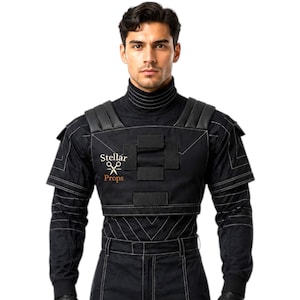 May include: Black jumpsuit with white stitching, a high collar, and padded shoulders. The outfit includes gloves and the text "Stellar Props" on the chest and leg. This costume is suitable for cosplay or theatrical productions.