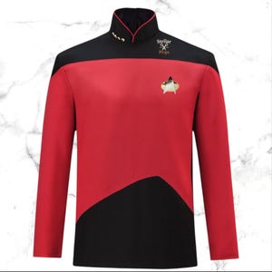 May include: A red and black Star Trek uniform shirt with a gold insignia and gold buttons on the collar. The shirt has long sleeves and a high collar. The Stellar Props logo is visible on the upper right.