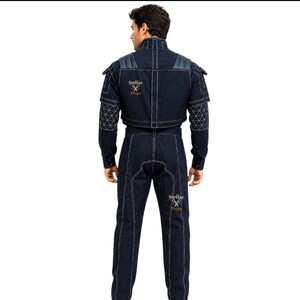 May include: A dark blue denim jumpsuit with white stitching and accents. The jacket has padded shoulders and geometric patterned sleeves. The text "Stellar Props" is printed on the back of the jacket and pants.