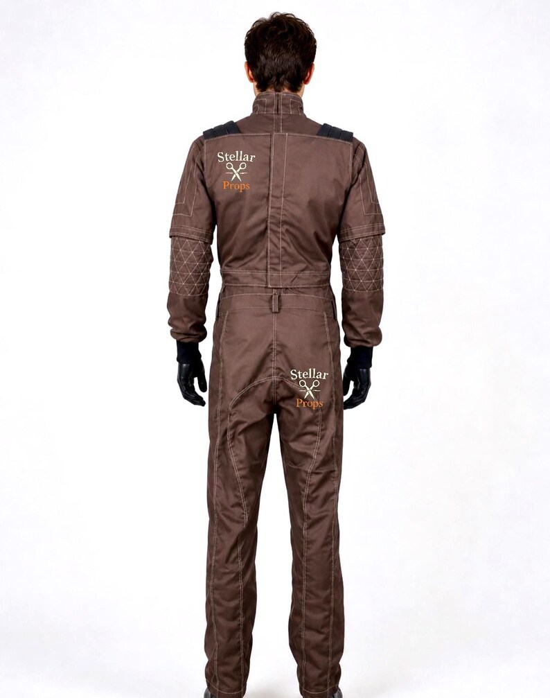 May include: A brown jumpsuit featuring long sleeves with quilted elbow patches, a high collar, and black gloves. The garment displays the text Stellar Props with a scissors icon on the upper back and the seat. It has visible white stitching.