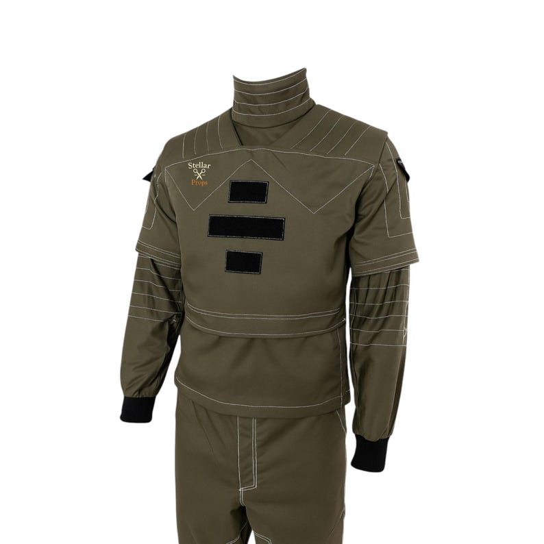 May include: Olive green protective suit with white stitching and black accents. The suit features a high collar, long sleeves, and a two-piece design. The text "Stellar Props" is visible on the upper left chest area.