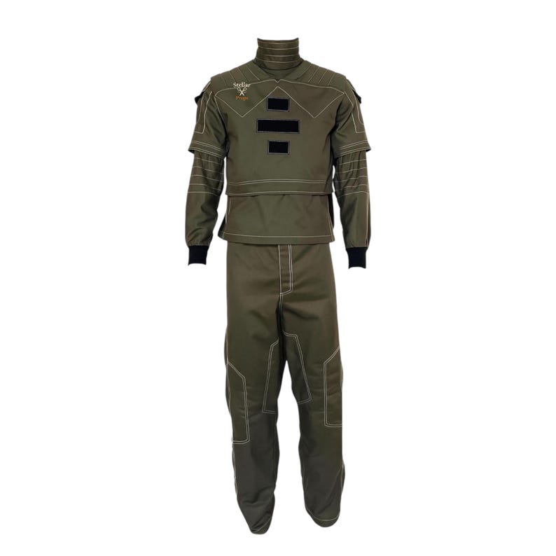 May include: Olive green protective suit with white stitching and black accents. The suit includes a high collar, long sleeves, and matching pants. The upper portion has black rectangular patches. The Stellar X logo is visible on the upper left.