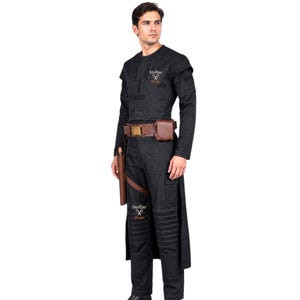 May include: Black costume with a long-sleeved jacket, pants, and a brown belt with a pouch. The costume includes a holster and the text "Stellar Props". The jacket has padded shoulders and the pants have knee padding. The costume is designed for cosplay or costume events.